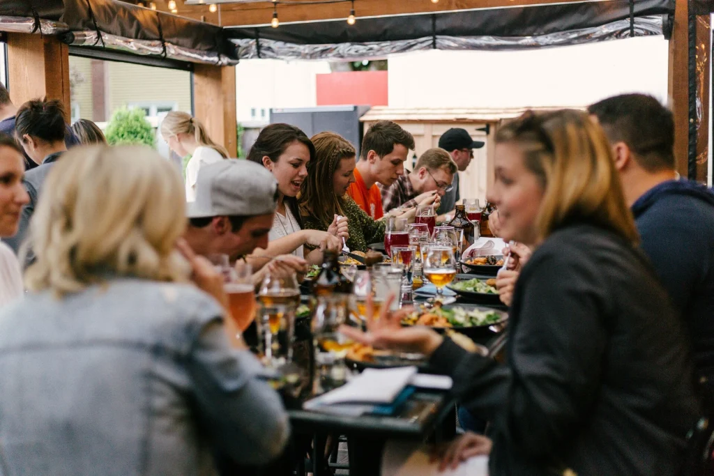 a group of people sitting at a table eating food
