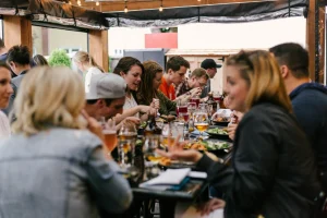 a group of people sitting at a table eating food