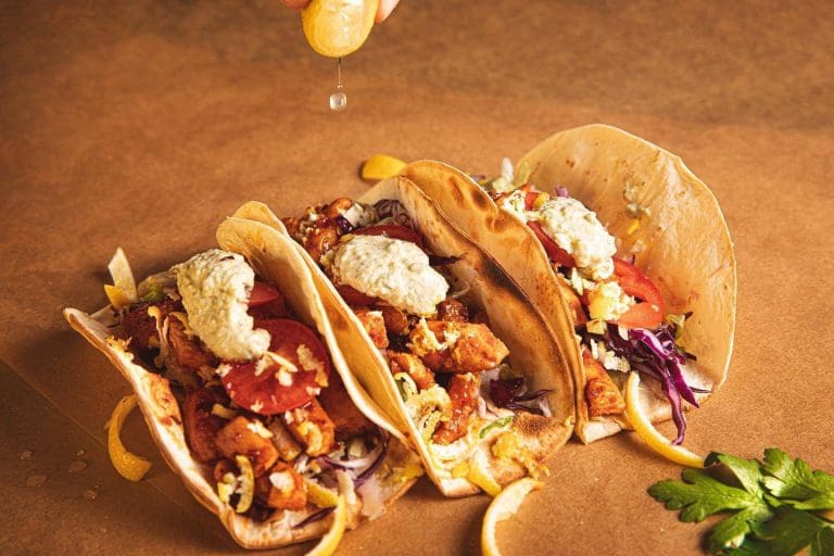 a group of tacos with a lemon juice
